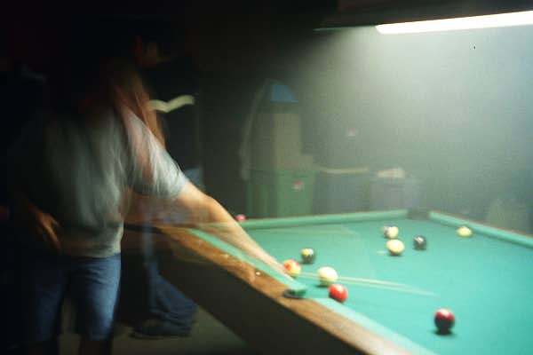 This picture turned out blurry, but you can definitely see someone is playing pool.. Becki perhaps?  They seem to have her long hair..