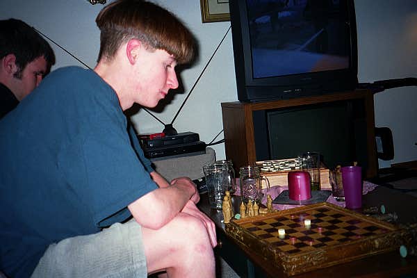 Is he playing checkers on that chess board?  And more importantly:  Is he playing checkers with himself?